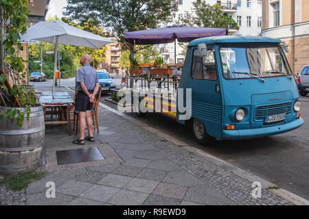 Berlin-Mitte. Happy Buddha indische Restaurant mit Tischen im Freien & zusätzliche Plätze auf einem geparkten Lkw Stockfoto