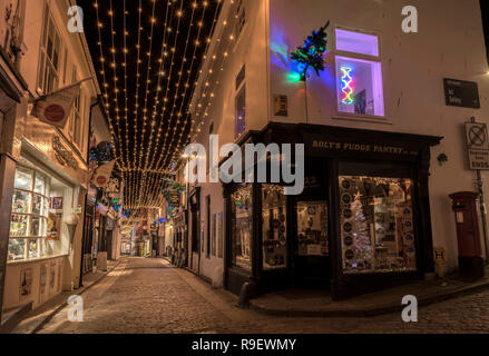 Hübsche Weihnachtsbeleuchtung und Weihnachtsbäume in den gepflasterten Straßen von St. Ives, Cornwall, Großbritannien Stockfoto