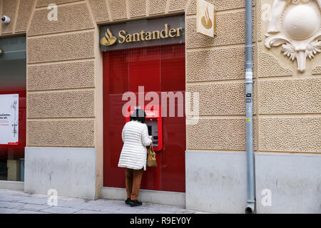 Eine Dame verwendet eine Santander ATM in Cartagena, Spanien Stockfoto