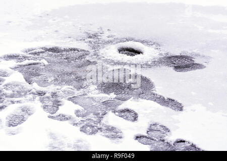 Loch im Eis des Sees für die eiskalte Winter angeln mit Spuren von Fischer. Stockfoto