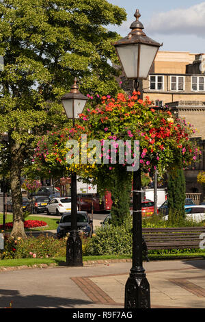 Altmodische Lampenpfosten mit Körben von bunten Sommerblumen, die von ihnen hängen, Crescent Gardens, Harrogate, North Yorkshire, England, VEREINIGTES KÖNIGREICH. Stockfoto