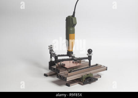 Gravur Gerät Stromabnehmer mit CNC-graveur mit Buchdruck Alphabet auf weißem Hintergrund Stockfoto