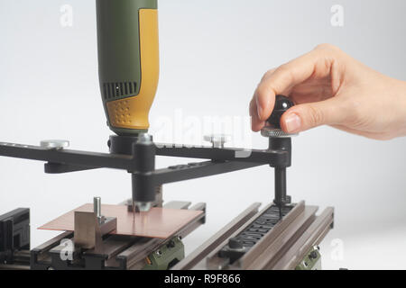 Arbeiter Hände an Gravur Gerät Stromabnehmer mit CNC-graveur mit Buchdruck Alphabet auf weißem Hintergrund Stockfoto
