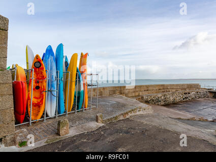 Mehrfarbige meer Kanus im Lagerregal in St Ives, an der nördlichen Küste von Cornwall. Stockfoto