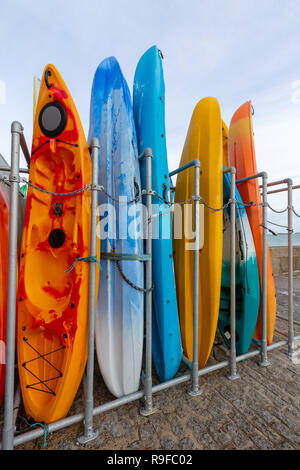 Mehrfarbige meer Kanus im Lagerregal in St Ives Harbour, an der nördlichen Küste von Cornwall. Stockfoto