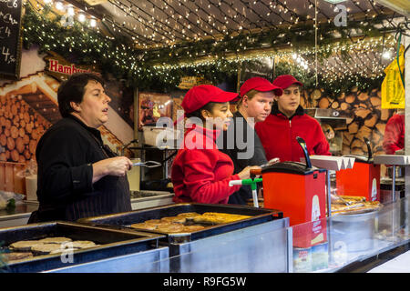 Straßenhändler in Fastfood stand verkaufen Hamburger in Weihnachtsmarkt im Winter in der Stadt Gent, Flandern, Belgien Stockfoto