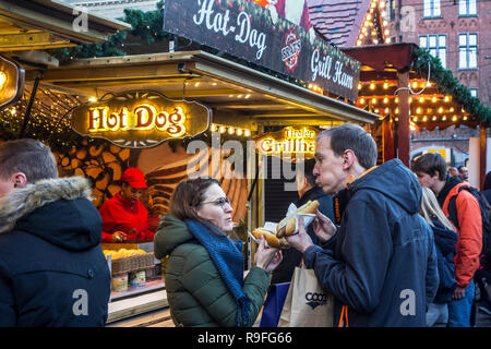 Besucher auf Fastfood stand Essen Hot Dogs am Weihnachtsmarkt Weihnachten feiern im Winter Stockfoto