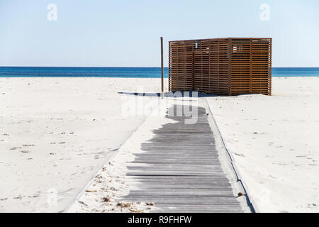 Baracca Bar aus Holz, geschlossen, auf dem einsamen weißen Strand mit der blauen Meer aus Sardinien im Hintergrund Stockfoto