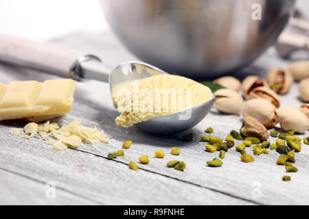 Pistazieneis Lufthutze mit gehackten Nüssen und weißer Schokolade auf einem urigen Hintergrund Stockfoto