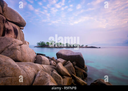 Sonnenaufgang an der Insel Bintan. Sand meer himmel wolken und Steine Stockfoto