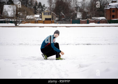 Runner Männer, die versuchen, Laufschuhe, die Vorbereitungen für den Winter laufen. Stockfoto