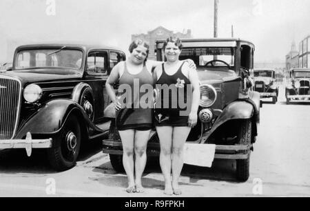 Zwei pralle Schwestern posieren vor Ihrem Auto auf dem Parkplatz von Coney Island, Ca. 1932. Stockfoto