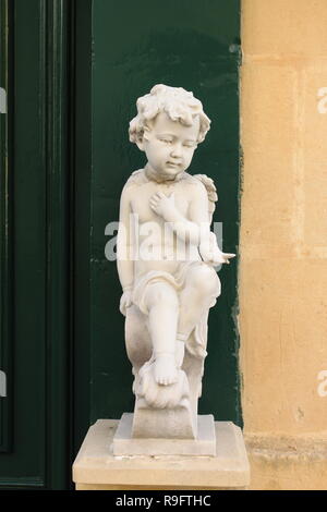 Cherub Engel Statue mit einer Hand auf der Brust Stockfoto