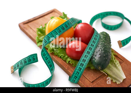 Bleiben Sie fit. Gesunde Ernährung, Diäten, abnehmen und Verlust Konzept wiegen - bis in der Nähe von Gemüse, Maßband und Salat Stockfoto