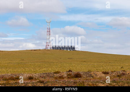 Turm der zellulären Kommunikation mit Sonnenkollektoren Stockfoto