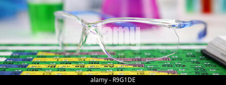 Schützende chirurgische oder Lab Gläser liegen auf periodische Tabelle Stockfoto
