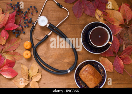 Bunte Blätter auf hölzernen Hintergrund medizinische Stethoskop Stockfoto