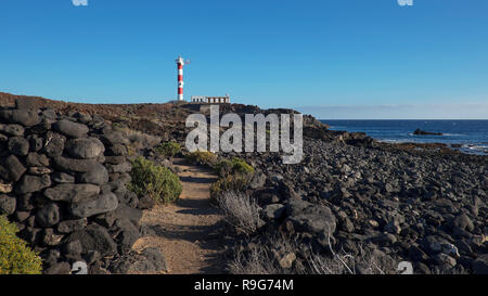 Trockene Landschaft von Malpais de la Rasca, einem Naturpark in der Nähe von Palm-Mar Stadt, mit Blick auf den Leuchtturm oder Faro Punta de Rasca Stockfoto