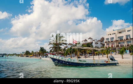 Costa Maya, Mexiko - 01. Februar 2016: Boot mit Flagge am tropischen Strand am Meer oder Ozean Wasser, weißer Sand, grüne Palmen, Tourist Resort an einem sonnigen Tag. Sommer Urlaub, Konzept reisen Stockfoto