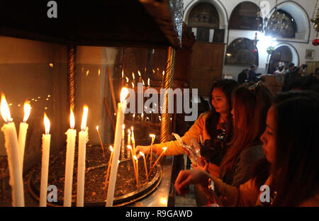 Bethlehem. 23 Dez, 2018. Anbeter Kerzen in der Kirche der Geburt Christi in der West Bank Stadt Betlehem, auf 23 Dezember, 2018, vor dem Weihnachtsfest. Credit: Mamoun Wazwaz/Xinhua/Alamy leben Nachrichten Stockfoto