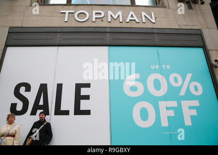 London, Großbritannien. 23 Dez, 2018. Ein paar werden gesehen, stand vor einer großen Verkauf Zeichen an der Topman Store Fenster auf dem Londoner Oxford Street. letzte Weihnachtskäufer profitieren Sie von Vorweihnachtlichen Schnäppchen auf der Oxford Street in London. Weniger Kunden wurden Einkaufen in hohen Großbritanniens Straßen als on-line-Verkäufe erhöhen berichtet. Credit: Dinendra Haria/SOPA Images/ZUMA Draht/Alamy leben Nachrichten Stockfoto