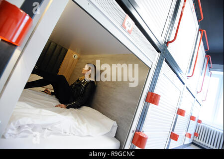 Warschau, Polen. 23 Dez, 2018. Eine Frau sitzt in ihrer Kapsel zum ersten japanischen Capsule Hotel in Warschau, Polen, 23 Dezember, 2018. Credit: Jaap Arriens/Xinhua/Alamy leben Nachrichten Stockfoto