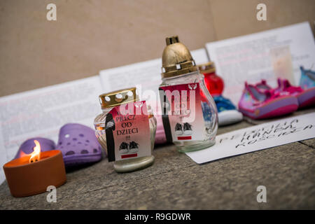 Warschau, Polen. 23 Dez, 2018. Kinder Schuhe, Kerzen und Plakate sind auf dem Boden während des Protestes gesehen. Der bundesweite Streik der Frauen (ogólnopolski Strajk Kobiet) organisiert die Kampagne 'Wir Pädophile" vorwerfen. Vor den Toren der Kirchen rund um Polen, Kinderschuhe wurden gehängt und Kerzen erhellte die Opfer der sexuell mißbrauchten Kinder durch katholische Priester zu gedenken. In Warschau, die Aktion fand in der Kirche in der Altstadt von St. Anne. Credit: SOPA Images Limited/Alamy leben Nachrichten Stockfoto