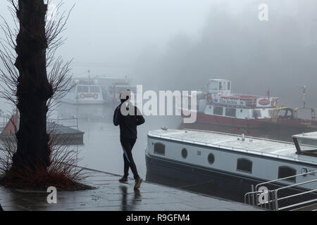 Chester, UK. 24. Dezember 2018. Nebel am frühen Morgen für einen Jogger, wie Sie laufen entlang des Flusses Dee an den Waldungen. Credit: Andrew Paterson/Alamy leben Nachrichten Stockfoto