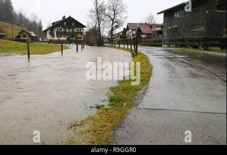 Fischen, Deutschland. 24 Dez, 2018. Ein Stream hat in Fischen (Bayern) auf einer Wiese entlang einer Straße gebildet. Nach starkem Regen und Tauwetter, einige Flüsse im Allgäu ihre Ufer getreten und landwirtschaftlichen Bereichen, aber es gab keine große Überschwemmungen. Credit: Benjamin Liss/dpa/Alamy leben Nachrichten Stockfoto