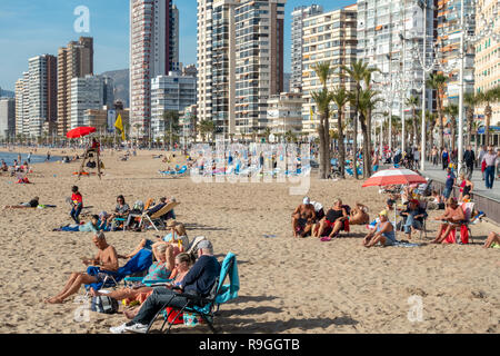 Benidorm, Costa Blanca, Spanien, 24. Dezember 2018. Britische Urlauber die Flucht aus der Kälte nach Hause Flut das beliebte Resort während der Weihnachtsferien. Sonnenanbeter und Schwimmer genießen Sie die heißen temps und ruhigem Wetter am Strand Levante heute in Benidorm an der Costa Blanca Küste. Die Temperaturen waren in den mittleren bis hohen 20 Celsius heute in diesem mediterranen Hotspot. Credit: Mick Flynn/Alamy leben Nachrichten Stockfoto