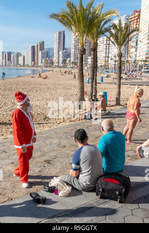 Benidorm, Costa Blanca, Spanien, 24. Dezember 2018. Britische Urlauber die Flucht aus der Kälte nach Hause Flut das beliebte Resort während der Weihnachtsferien. Dieser Mann hat als Als Weihnachtsmann verkleidet. Sonnenanbeter und Schwimmer genießen Sie die heißen temps und ruhigem Wetter am Strand Levante heute in Benidorm an der Costa Blanca Küste. Die Temperaturen waren in den mittleren bis hohen 20 Celsius heute in diesem mediterranen Hotspot. Credit: Mick Flynn/Alamy leben Nachrichten Stockfoto