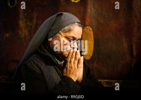 Bethlehem, Palästina. Autonomen Gebieten. 24 Dez, 2018. Eine Nonne betet in der Geburtskirche in Bethlehem. Christen aus aller Welt Weihnachten gefeiert im Heiligen Land am Montag. Viele Gläubige an der zentralen Krippenplatz in Bethlehem Weihnachten versammelt die traditionelle Prozession von Jerusalem zu erhalten. Credit: Ilia Yefimovich/dpa/Alamy leben Nachrichten Stockfoto