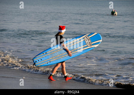 Cocoa Beach, Florida, USA. Dezember 24, 2018 Für die letzten neun Jahre, bevor Santa liefert Spielwaren und Geschenke, er brechen weg, einige Wellen in Cocoa Beach am Heiligabend Morgen zu erwischen. Die Surfing Santa's Event ist eine jährliche Cocoa Beach Tradition, bringt Hunderte Surfer gekleidet wie santa zu einem der berühmtesten Strände der Welt. Foto: Julian Porree/Alamy leben Nachrichten Stockfoto