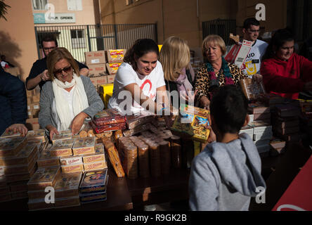 Malaga, Malaga, Spanien. 24 Dez, 2018. Ein freiwilliger gesehen, Kekse, um ein Kind während der jährlichen Nächstenliebe Verteilung der Lebensmittel von der NRO "Ãngeles MalagueÃ±os de la noche'' (Malaga's Engel der Nacht). Diese Organisation jeder 24. Dezember am Heiligabend Hunderte von Lebensmittel an bedürftige Menschen in der Stadt zu verteilen. Credit: Jesus Merida/SOPA Images/ZUMA Draht/Alamy leben Nachrichten Stockfoto