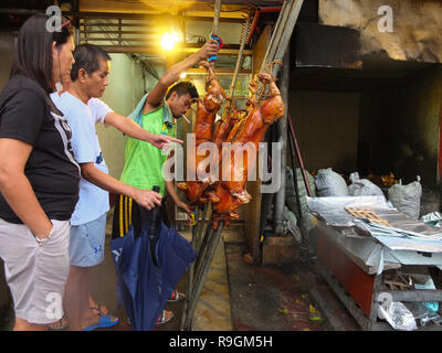 Quezon City, Philippinen. 15 Mär, 2012. Kunden, die Wahl zu seinen bevorzugten Eingegeben von Gattungen. Die lechon ist eine traditionelle philippinische Lebensmittel mit einem hohen Bedarf an Weihnachten. Credit: Josefiel Rivera/SOPA Images/ZUMA Draht/Alamy leben Nachrichten Stockfoto