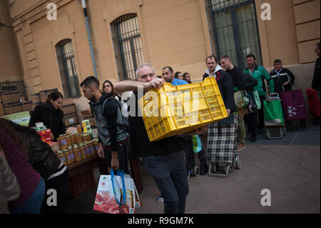 Malaga, Spanien. 24 Dez, 2018. Ein freiwilliger gesehen wird eine Box mit Essen während der jährlichen Nächstenliebe Verteilung der Lebensmittel von der NRO "malagueños Ángeles de La Noche" (Malaga's Engel der Nacht). Diese Organisation jeder 24. Dezember am Heiligabend Hunderte von Essen verteilen, um bedürftigen Menschen in der Stadt. Credit: SOPA Images Limited/Alamy leben Nachrichten Stockfoto