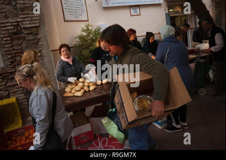 Malaga, Spanien. 24 Dez, 2018. Die Menschen gesehen, die Lebensmittel aus Freiwilligen während der jährlichen Nächstenliebe Verteilung der Lebensmittel von der NRO "malagueños Ángeles de La Noche" (Malaga's Engel der Nacht). Diese Organisation jeder 24. Dezember am Heiligabend Hunderte von Essen verteilen, um bedürftigen Menschen in der Stadt. Credit: SOPA Images Limited/Alamy leben Nachrichten Stockfoto