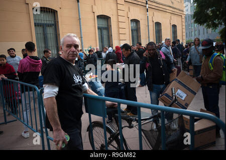 Malaga, Spanien. 24 Dez, 2018. Die Menschen sind zu sehen auf der Straße essen zu empfangen während der jährlichen Nächstenliebe Verteilung der Lebensmittel von der NRO "malagueños Ángeles de La Noche" (Malaga's Engel der Nacht). Diese Organisation jeder 24. Dezember am Heiligabend Hunderte von Essen verteilen, um bedürftigen Menschen in der Stadt. Credit: SOPA Images Limited/Alamy leben Nachrichten Stockfoto