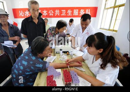 (181225) - Peking, 25. Dez., 2018 (Xinhua) - ein Arzt nimmt eine Blutprobe für eine Frau an Suzhuang Dorf Qinshui Duanshi Stadt im County, im Norden der chinesischen Provinz Shanxi, 21. Juli 2014. Die chinesische Regierung hat 5,95 Billionen Yuan (rund 862 Milliarden US-Dollar) für medizinische Leistungen von 2013 bis 2017, mit einem durchschnittlichen jährlichen Zuwachs von 11,7 Prozent, nach einem Bericht der Nationalen Volkskongress vorgelegt, China's Top Gesetzgebung. Chinas Geschäftsjahr Ausgaben für medizinische Leistungen im Jahr 2017 war 1,4 Billionen Yuan, eine 55,5-prozentige Zunahme von 2013, Buchhaltung für 7,1 Prozent der nationalen f Stockfoto