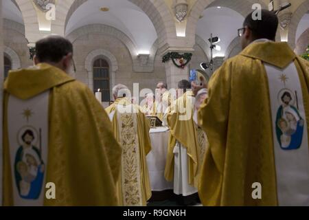 Bethlehem, West Bank, Palästina. 25 Dez, 2018. Erzbischof Pierbattista Pizzaballa, oben Römisch-katholischen Kleriker im Heiligen Land, in der Mitte einen weihnachtlichen Mitternachtsmesse in Saint Catherine's Kirche, in der Kirche der Geburt, die traditionell von Christen anerkannt der Geburtsort von Jesus Christus zu sein, die in der West Bank Stadt Bethlehem, am Dienstag, den 25. Dezember 2018 Credit: Nasser Nasser/APA-Images/ZUMA Draht/Alamy leben Nachrichten Stockfoto