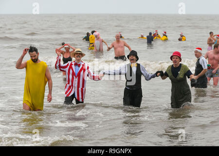 Charmouth, Dorset, Großbritannien. 25 Dez, 2018. Weihnachtstag Schwimmer tragen Fancy Dress Braving das kühle Wasser ein erfrischendes Bad im Meer bei Charmouth, Dorset zu nehmen Geld für die Rnli zu erhöhen. Foto: Graham Jagd-/Alamy leben Nachrichten Stockfoto