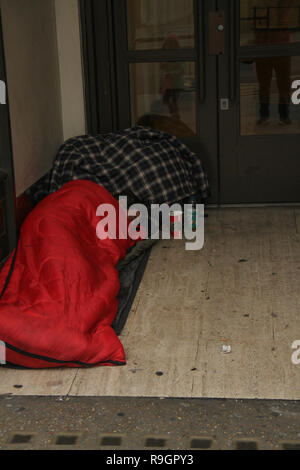 London, Großbritannien. 25 Dez, 2018: eine obdachlose Person schläft durch eine Tür in ein Geschäft auf Regents Street am Weihnachtstag mit keine öffentlichen Verkehrsmittel läuft am 25. Dezember 2018. Einige Teile der Stadt erlebte dichten Nebel, der voraussichtlich für den Rest der Woche zum Verweilen ein. Quelle: David Mbiyu/Alamy leben Nachrichten Stockfoto