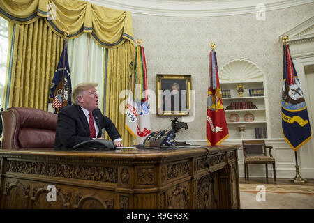 Washington DC, USA. 25. Dez 2018. Präsidenten der Vereinigten Staaten Donald J. Trumpf macht einen Videoanruf zu Mitgliedern aus der Armee, Marine Corps, Navy, Air Force, und Küstenwache stationiert weltweit in das Oval Office im Weißen Haus in Washington, DC, USA, am 25. Dezember 2018. Credit: ZUMA Press, Inc./Alamy leben Nachrichten Stockfoto