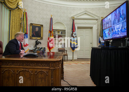 Washington, DC, USA. 25 Dez, 2018. Präsidenten der Vereinigten Staaten Donald J. Trumpf macht einen Videoanruf zu Mitgliedern aus der Armee, Marine Corps, Navy, Air Force, und Küstenwache stationiert weltweit in das Oval Office im Weißen Haus in Washington, DC, USA, am 25. Dezember 2018. Credit: Zach Gibson/Pool über CNP | Verwendung der weltweiten Kredit: dpa/Alamy leben Nachrichten Stockfoto
