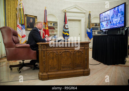 Washington, DC, USA. 25 Dez, 2018. Präsidenten der Vereinigten Staaten Donald J. Trumpf macht einen Videoanruf zu Mitgliedern aus der Armee, Marine Corps, Navy, Air Force, und Küstenwache stationiert weltweit in das Oval Office im Weißen Haus in Washington, DC, USA, am 25. Dezember 2018. Credit: Zach Gibson/Pool über CNP | Verwendung der weltweiten Kredit: dpa/Alamy leben Nachrichten Stockfoto