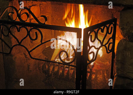 Flammen von einem echten Feuer, in einer gusseisernen Gitter, Winter, schöne orange Warm glow Stockfoto