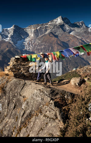 Nepal, Namche Bazar, Senior Trekker ruht neben Gebetsfahnen fliegen von rauen Rocky chorten Stockfoto