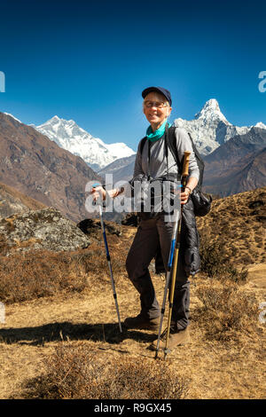 Nepal, Everest Base Camp Trek, Senior weiblichen Trekker mit Stöcke unter Himalaya Stockfoto