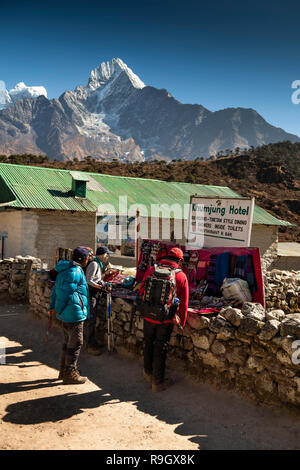 Nepal, Everest Base Camp Trek, Khumjung Dorf, Trekker und Sherpa Guide an kleinen touristischen souvenir Abschaltdruck außerhalb der lokalen Guest House Lodge Stockfoto