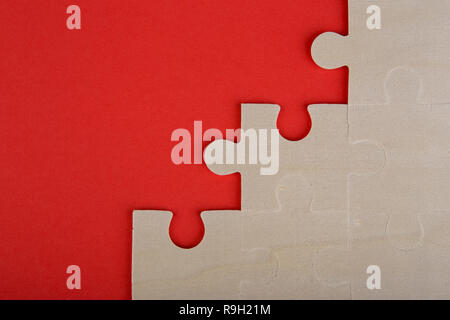 Holzpuzzle Stücke auf einem roten Hintergrund Stockfoto